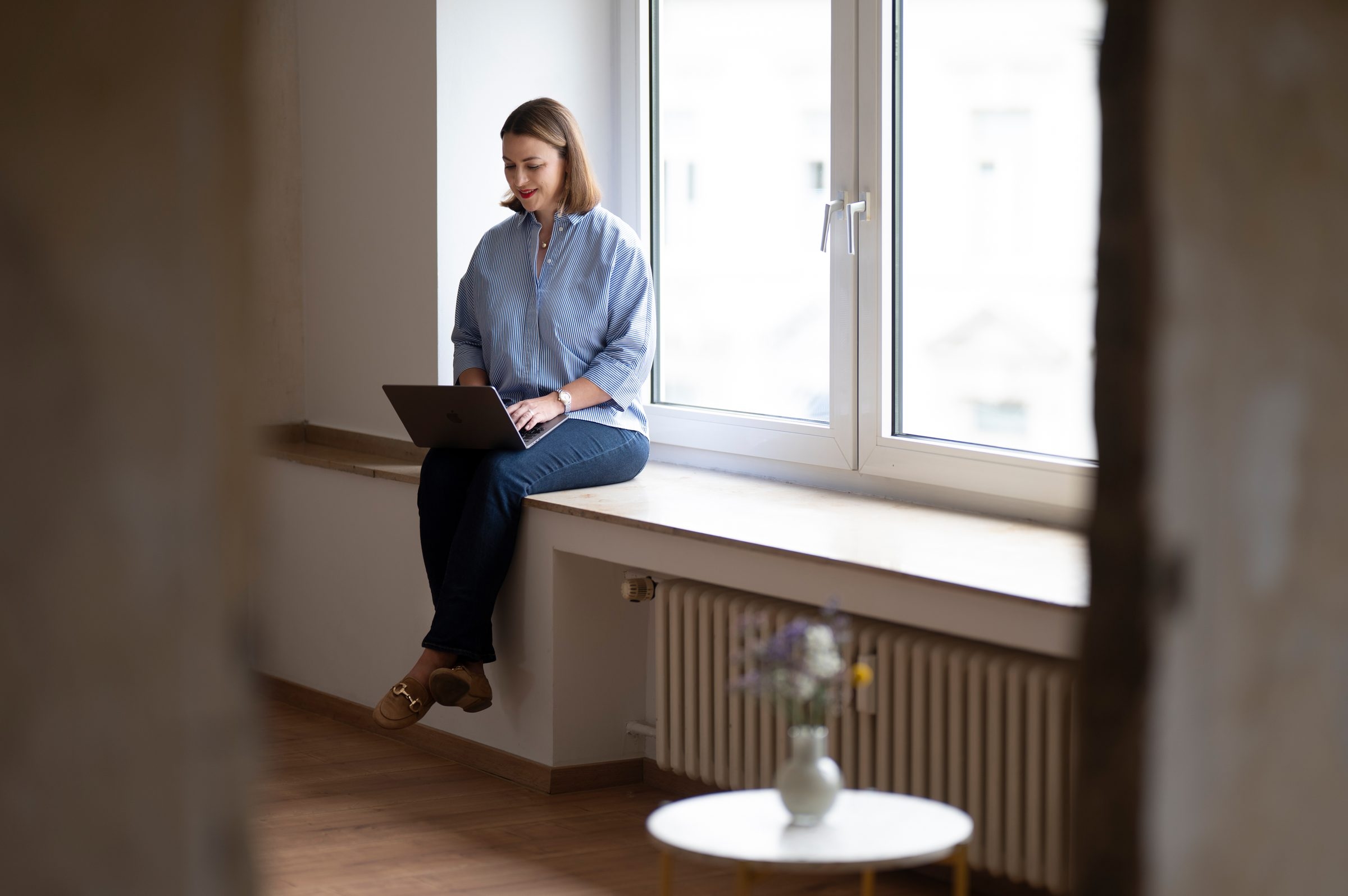 Victoria Beckers von Energie durch Entwicklung telefoniert und hält eine Kaffeetasse in der Hand – Momentaufnahme durch eine Glasscheibe, die Fokus und Ruhe vermittelt. Victoria Beckers von Energie durch Entwicklung telefoniert und hält eine Kaffeetasse in der Hand – Momentaufnahme durch eine Glasscheibe, die Fokus und Ruhe vermittelt.